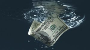 Money sinking into water