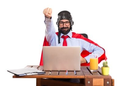 man in a suit wearing a superhero cape representing the work hero identity in the work