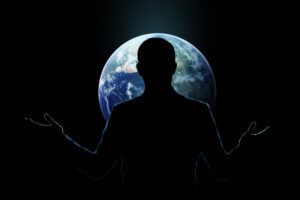 Man overwhelmed by global digital workload standing in front of a world backdrop symbolising constant availability