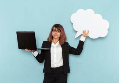 Professional woman holding a laptop beside a white bubble representing Gen Z communication and digital clarity