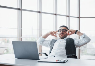 Young man working on a laptop while emotionally detached, representing silent burnout and autopilot at work