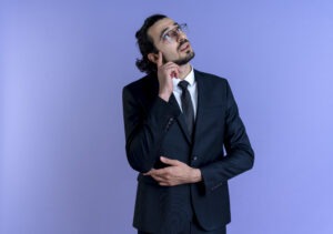 Professional in a black suit looking up in thought, reflecting on career direction and uncertainty