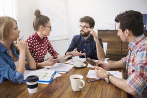 Team exchanging ideas in a modern workspace reflecting a human centred communication style