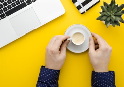 A calm desk with a laptop and a warm coffee mug in morning light, symbolizing micro awakenings at work and the quiet moments that reset attention.