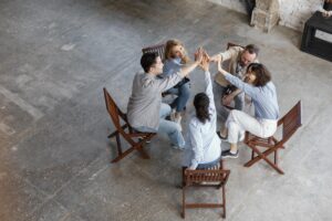A group of colleagues sitting in a circle and pausing together, symbolizing micro awakenings at work and shared presence in a modern workplace.