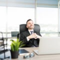 Calm business leader sitting at a desk in a modern office, focused and thoughtful in a quiet work environment
