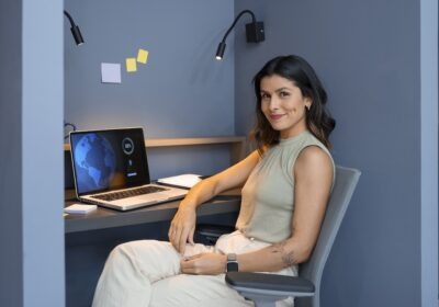 A young woman smiling while using her laptop, representing a confident modern professional embracing a flexible and multi identity career path.