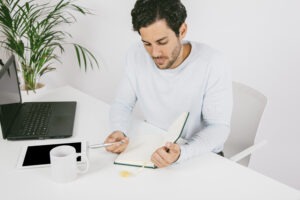 Calm professional writing in a notebook while taking a break at work